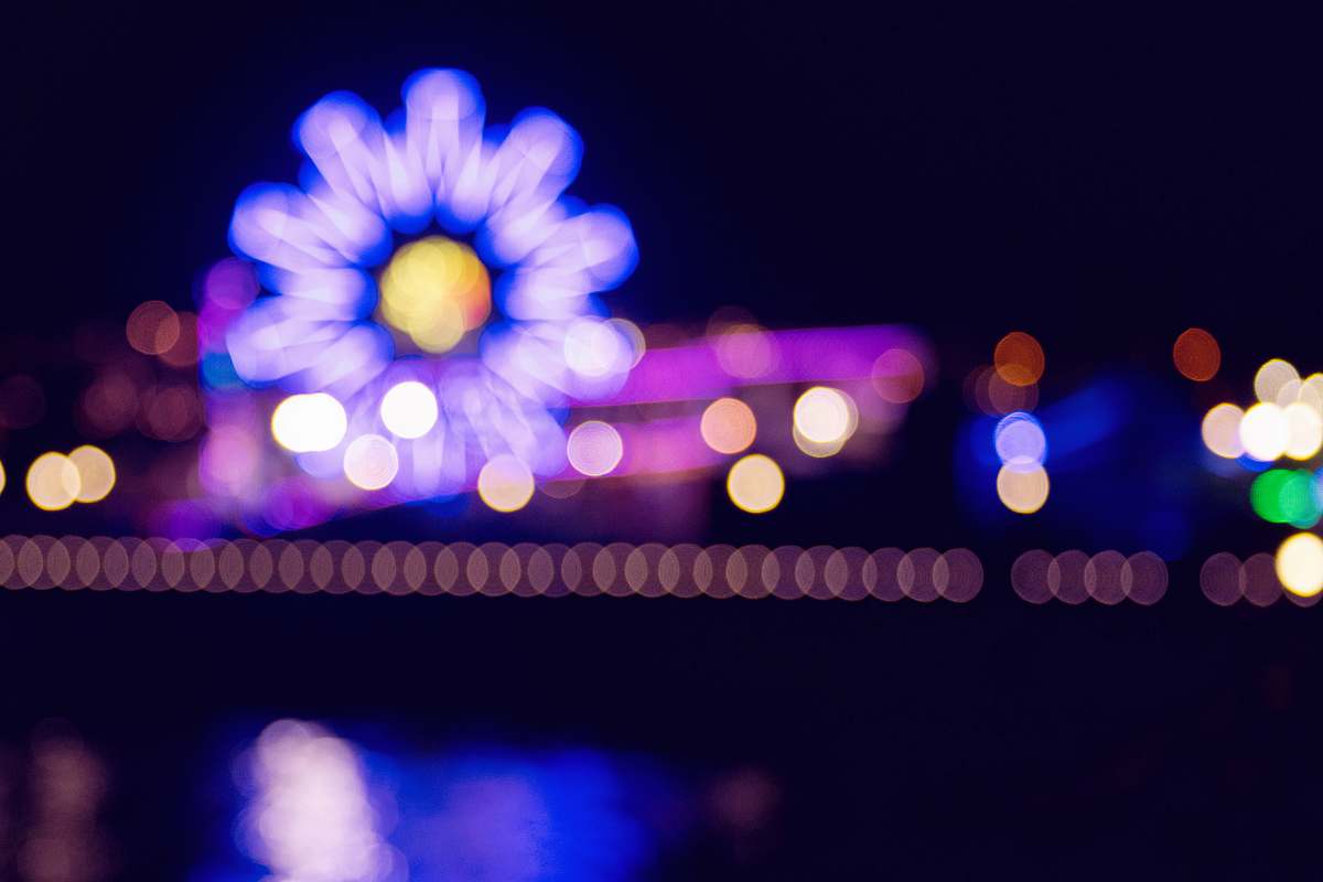 lighting bokeh photography of ferris wheel during nighttime santa monica beach